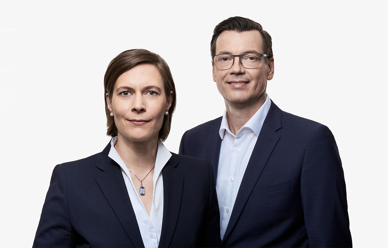 Ein koloriertes Bild der Partner bei Braun&Westenberger Immobilienbewertung, Sachverständiger für Bewertung von bebauten und unbebauten Grundstücken, zeigt zwei Personen. Eine Frau und Mann sind in Businessanzüge gekleidet.